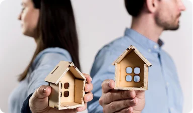 Woman and man holding a toy construction of the house